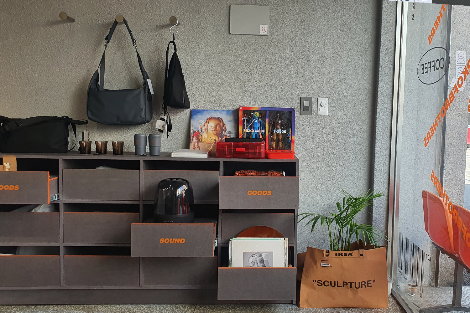 Arkofbrothers咖啡廳牆上展示的藝術作品，在橙色背景中突出了獨特個性。