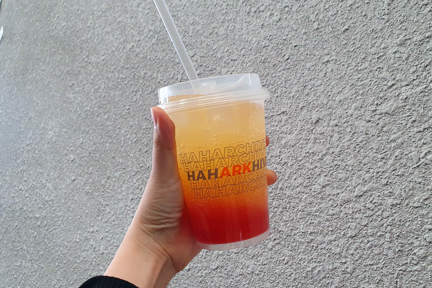 Arkofbrothers的橙色主題飲品，玻璃杯上印刷品牌標誌，突出咖啡廳獨特風格。