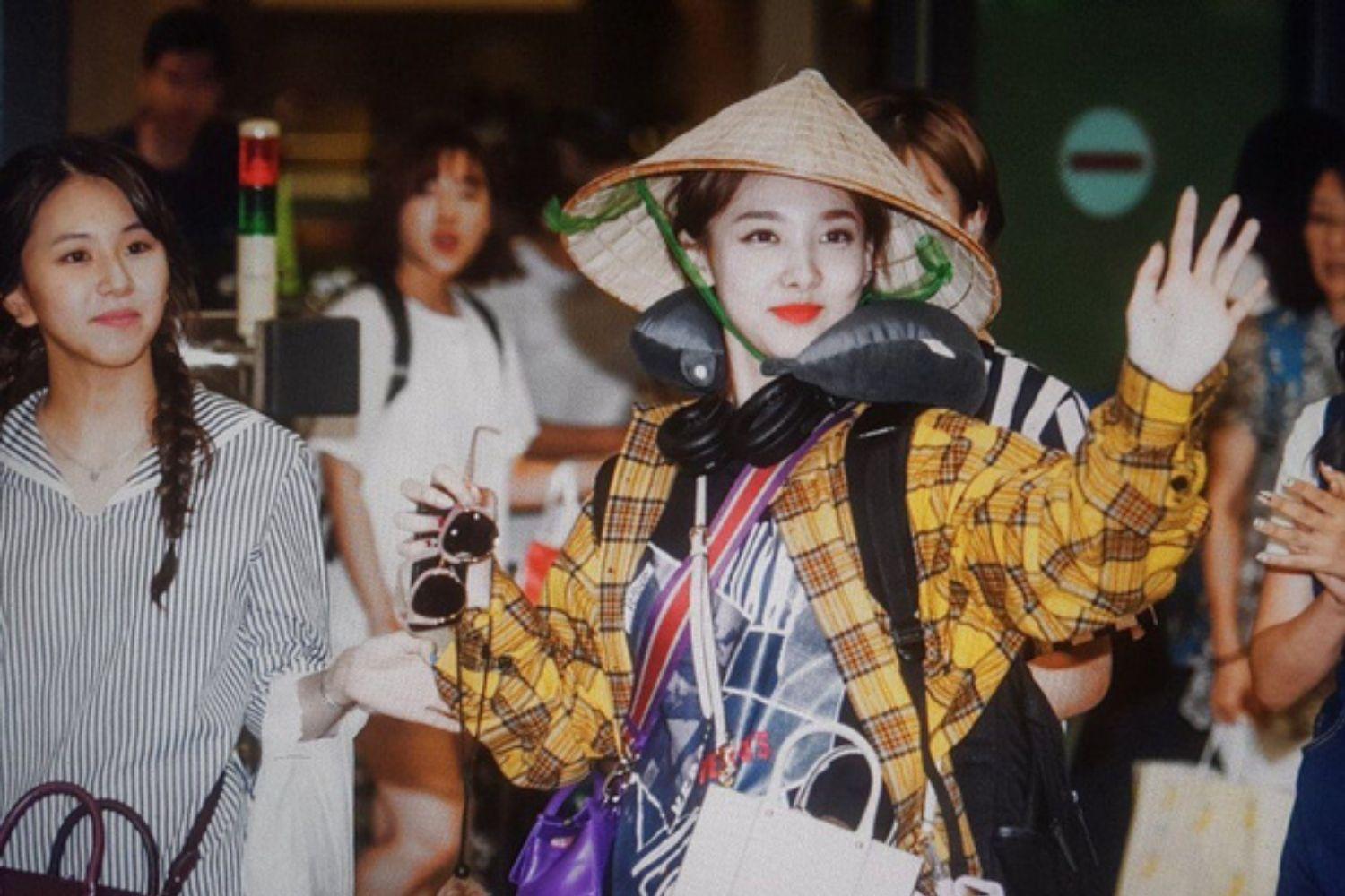 Nữ thần tượng Kpop mặc áo sơ mi kẻ sọc và đội nón lá Việt Nam, thể hiện sự tôn trọng văn hóa nước chủ nhà.