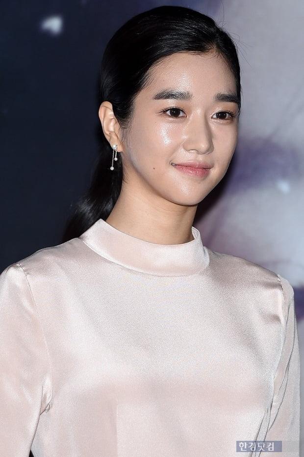 白い襟のシルク調の衣装を着た韓国の女性有名人、背景は宇宙を思わせるデザイン、日本語でニュース記事の一部が公開されている。