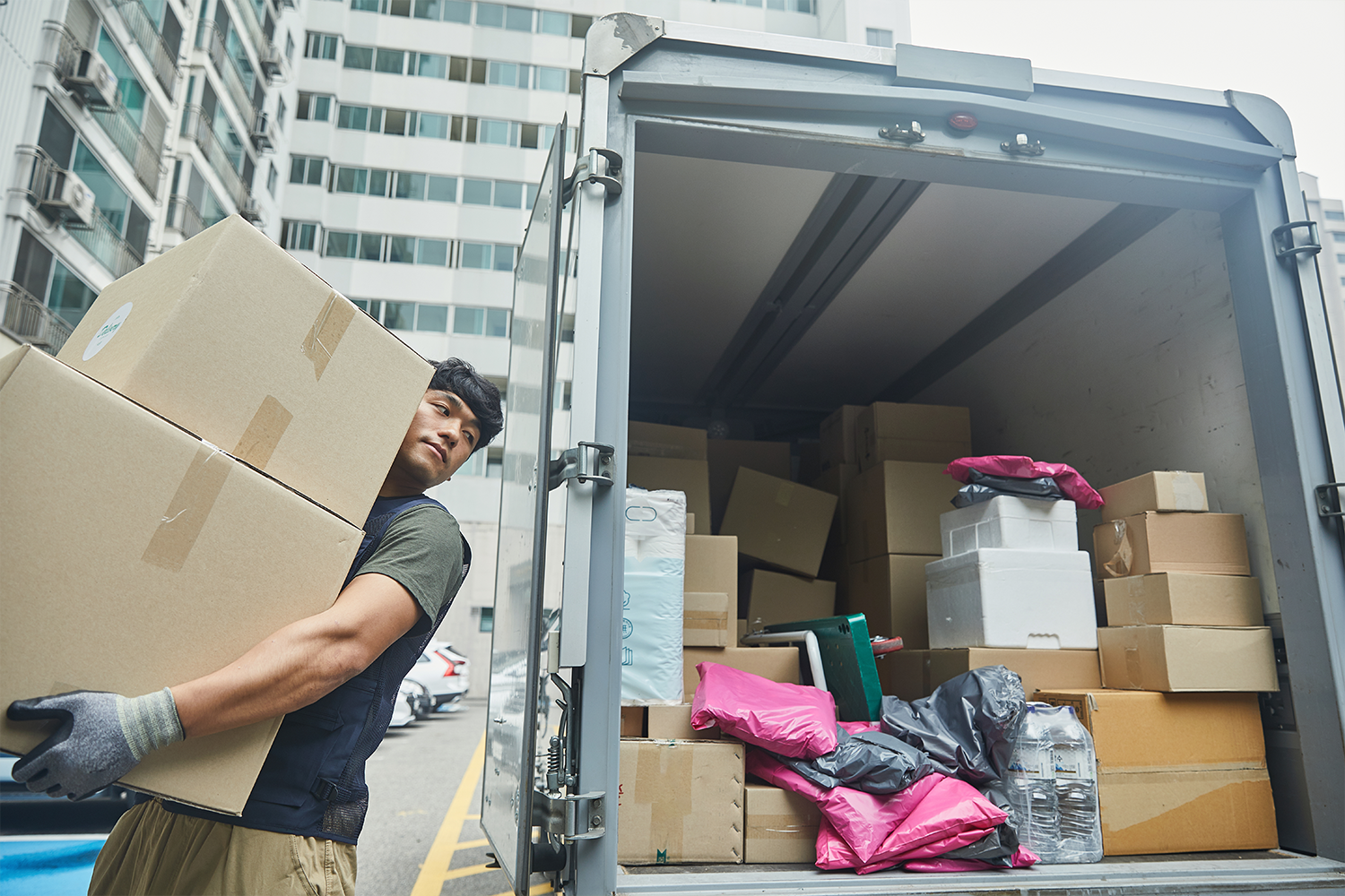 delivery man putting package box in truck