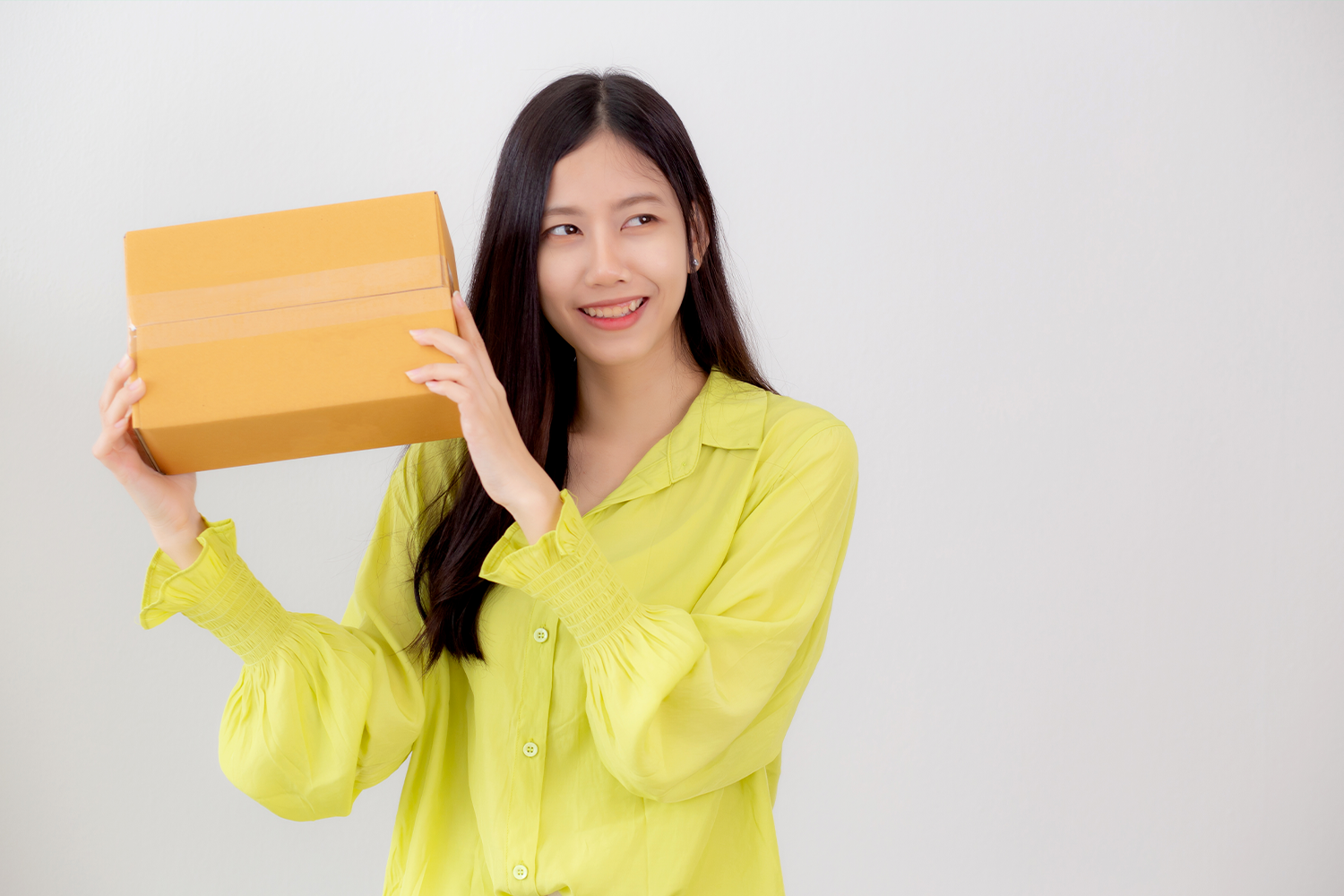 Persona sosteniendo un paquete, representando la conveniencia de los servicios de entrega rápida en Corea.