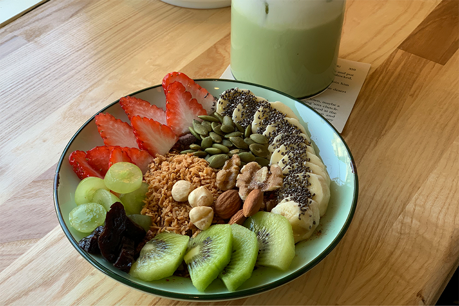 特写图展示了Riverway咖啡厅的有机燕麦碗，配有多种新鲜水果和坚果。