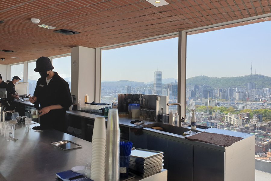 T(ER)T(RE)咖啡厅内，工作人员在吧台后忙碌，展示了咖啡厅的运营状况与背后支持的团队。