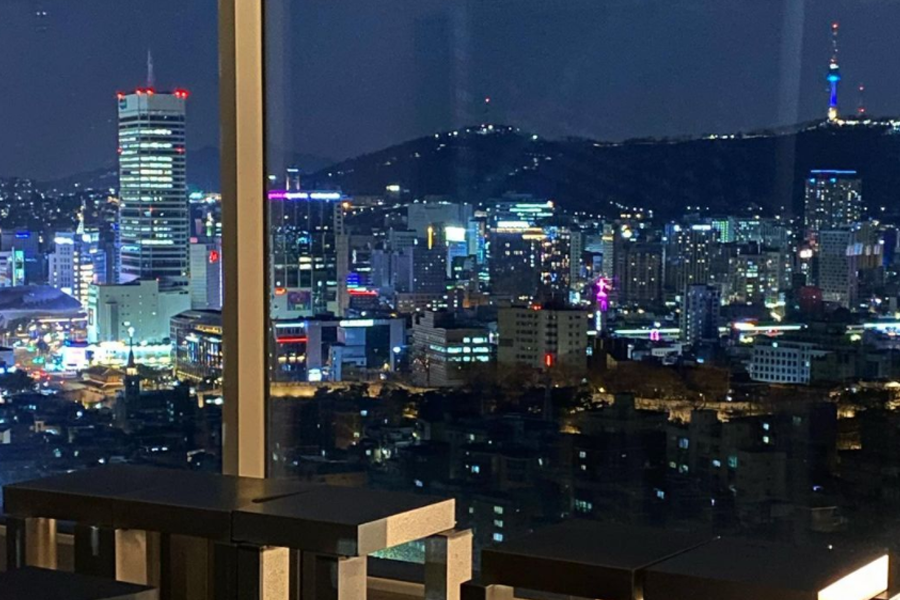 T(ER)T(RE)咖啡厅夜间风景，城市灯火辉煌，展现首尔的夜生活和城市活力。