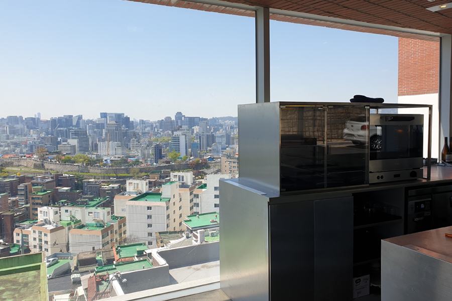 T(ER)T(RE)咖啡厅内视图，宽大的落地玻璃窗让客人可以欣赏到东大门区的壮丽城市景观，室内充满现代感。