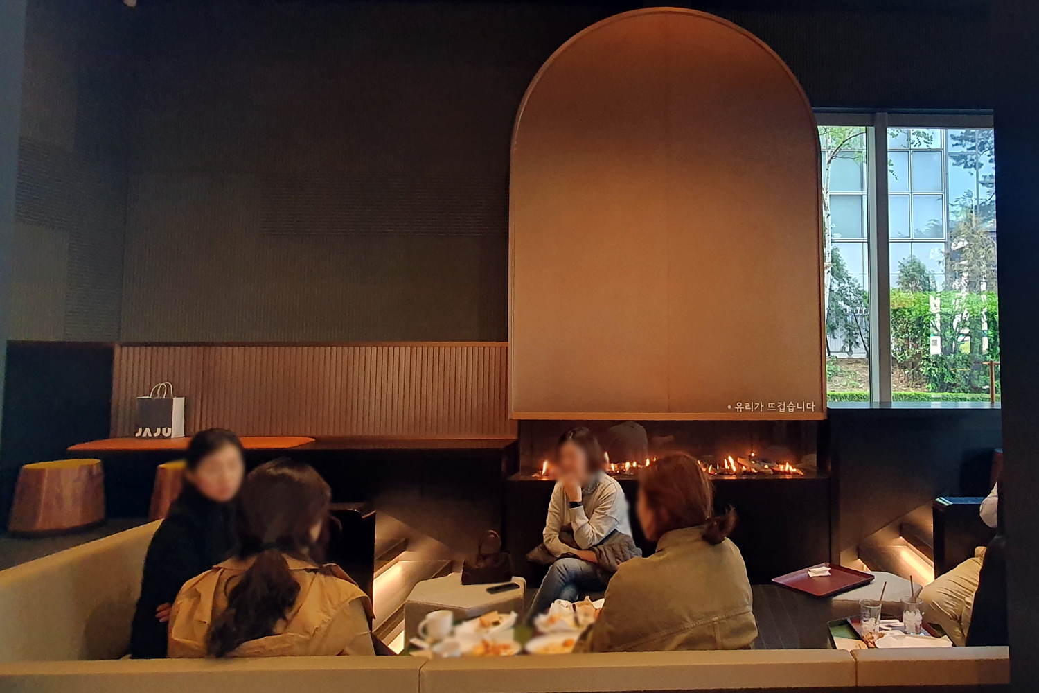 Starbucks Byeoldabang people sitting on sofa around fireplace