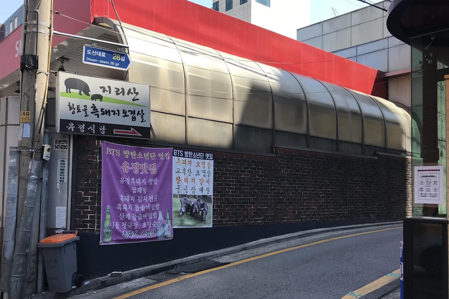 智異山黃土谷土種黑豬餐廳入口，門口掛有BTS廣告牌