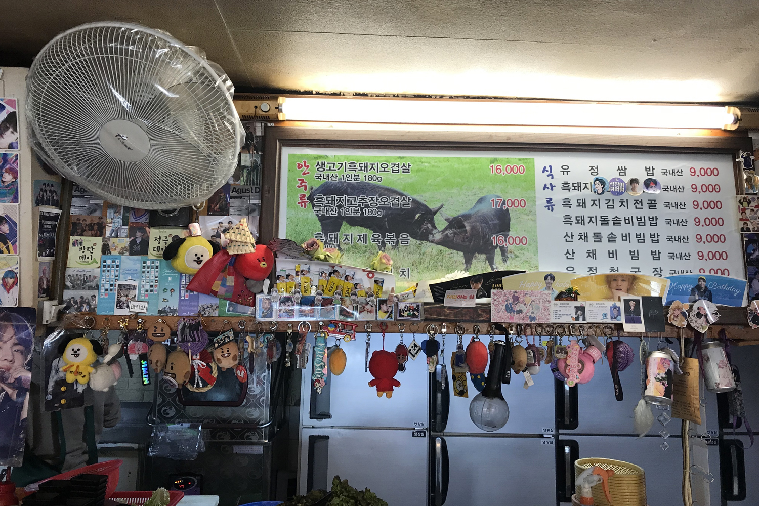 智異山黃土谷土種黑豬餐廳的展示台，上面擺滿防彈少年團的相關商品和紀念品