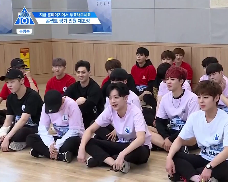 Korean idols sitting on the floor with their legs crossed