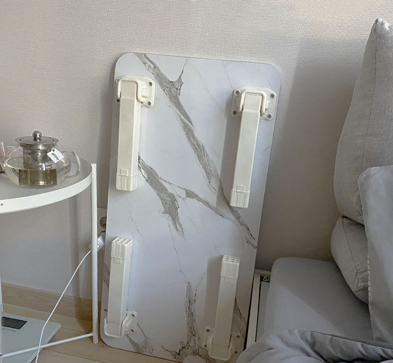 folded white marble low table next to bed