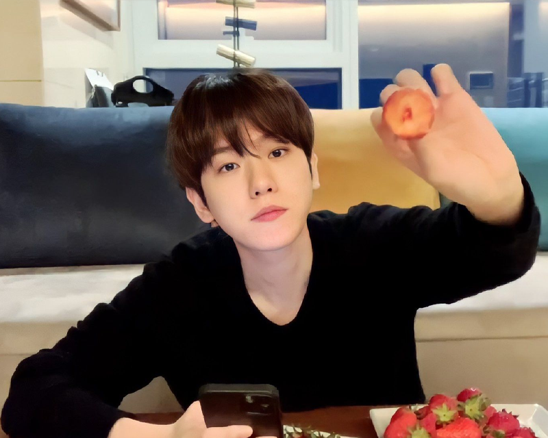 Korean idol showing strawberry sitting on the floor