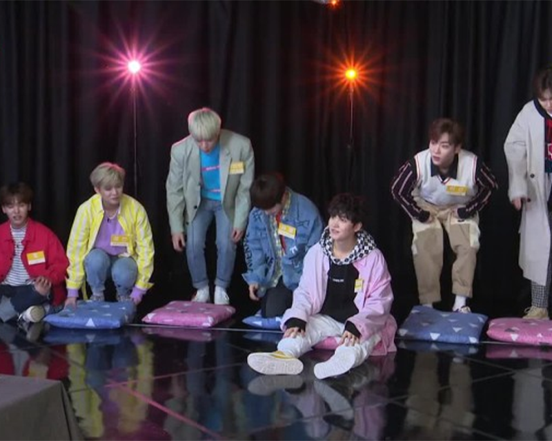 kpop idols sitting on seat cushion
