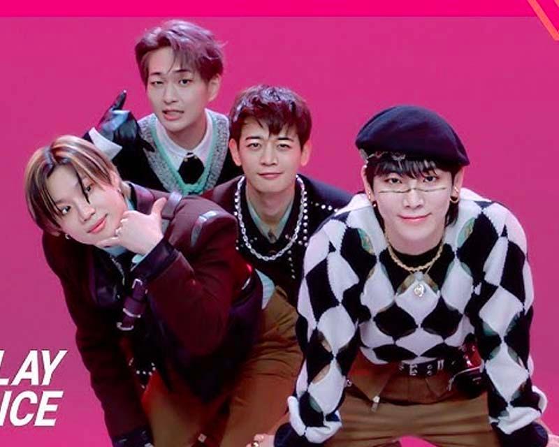 SHINee 成員穿著別緻的黑色服裝在粉紅色背景下擺出姿勢