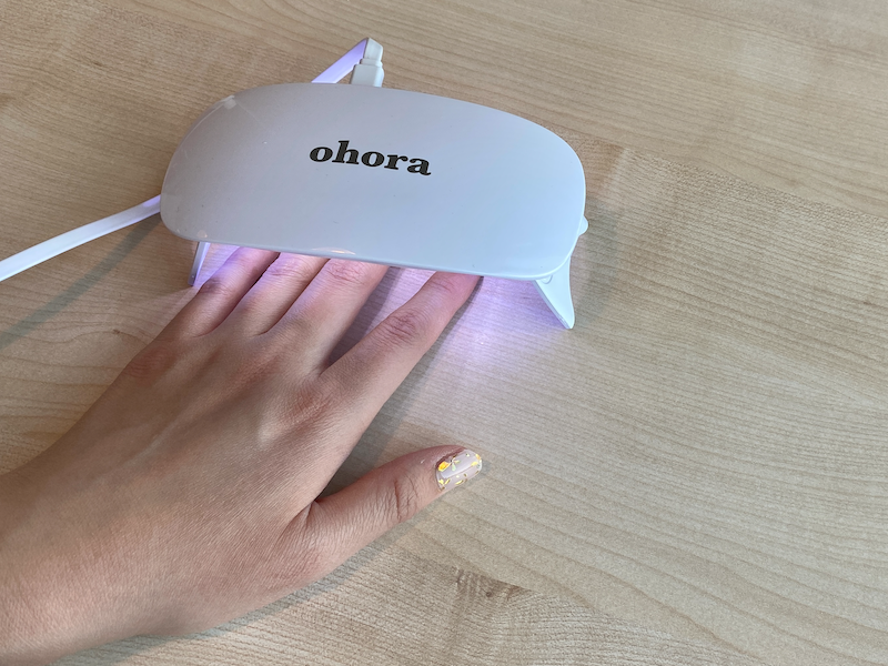 Proceso de aplicación de pegatinas de uñas, mostrando una lima de uñas usada para eliminar el exceso de sticker.