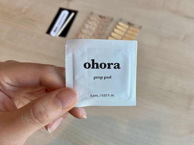 Un kit de Ohora con pegatinas de uñas de gel y herramientas para la aplicación, destacando un diseño elegante.