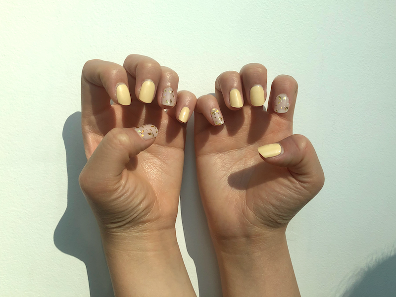 Manos con uñas perfectamente cuidadas, exhibiendo el resultado final de la aplicación de pegatinas de uñas.