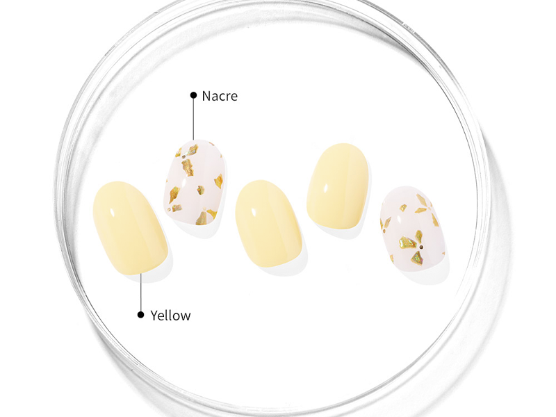 Mano mostrando uñas pintadas en tonos pastel de primavera con un diseño floral minimalista.