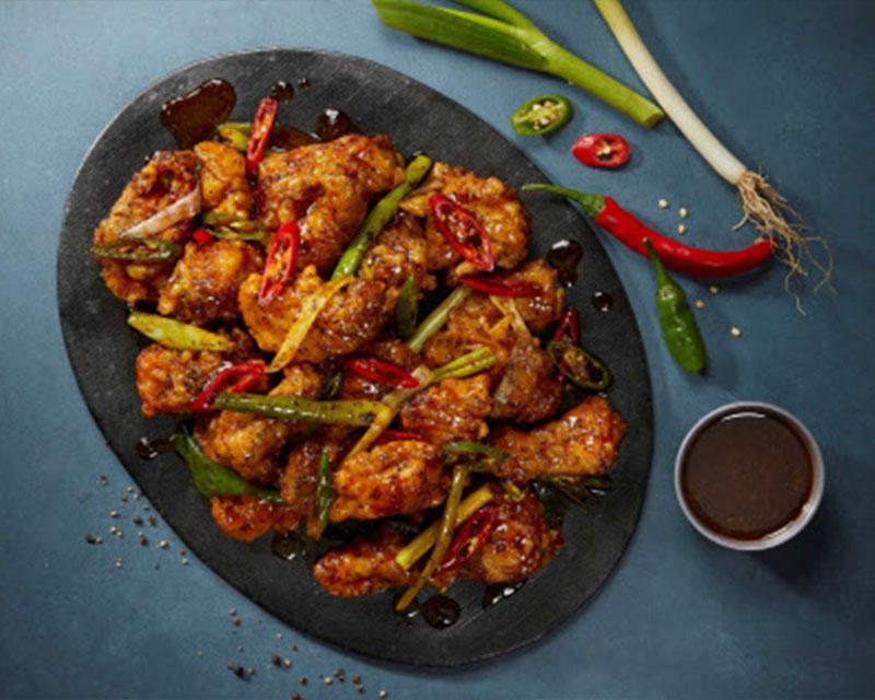 BBQ幹烹炸雞，搭配蒜香、辣味、酸甜的醬汁，配上葱和辣椒，提升風味。