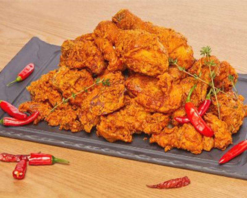 韓國黃色炸雞新口味，外脆內辣，旁邊配有紅辣椒，代表著刺激的辛辣味。