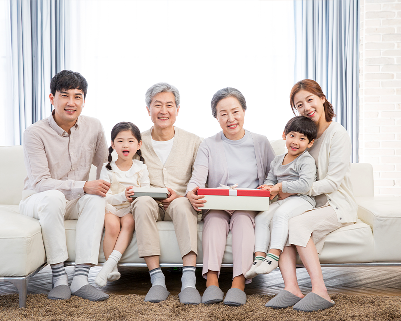A Korean family happily gathered on a sofa