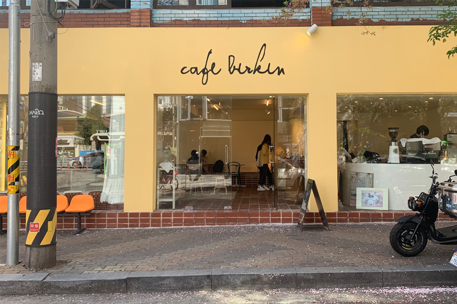 Cafe Birkin正面外观，带有明亮鹅黄色，吸引眼球的咖啡店设计。
