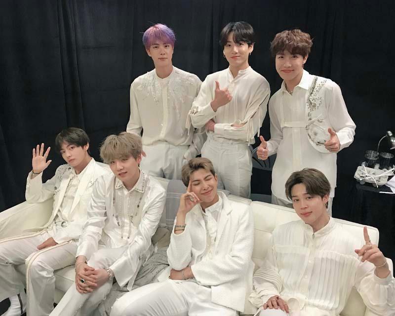 BTS ถ่ายภาพรวมกลุ่มในชุดสีขาว คล้ายกับภาพเบื้องหลังหรือระหว่างซ้อม บรรยากาศสบายๆ
