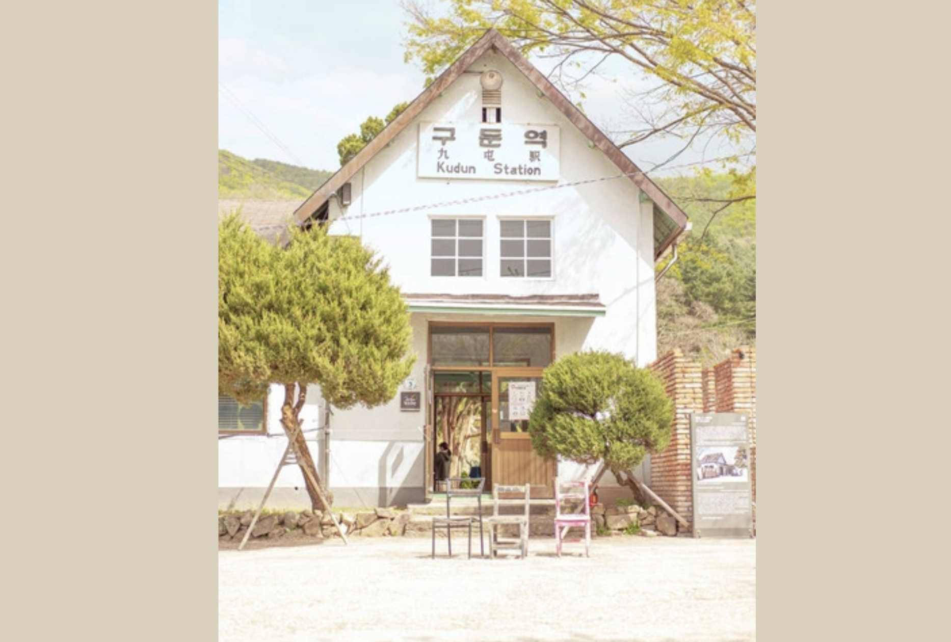 韓国楊平郡の九屯駅の前景。白い壁と三角屋根のレトロな木造建築が特徴的で、正面には椅子が並べられている。