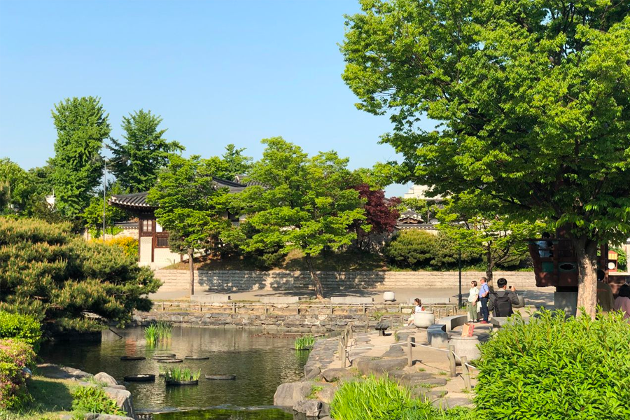 Lakeside view in Namsan Hanok Village, with visitors enjoying the serene beauty of traditional Korean architecture.