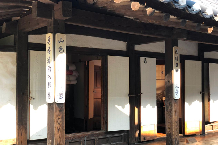 Exterior view of traditional Korean hanok with calligraphed signboards at Namsan Hanok Village, Seoul.