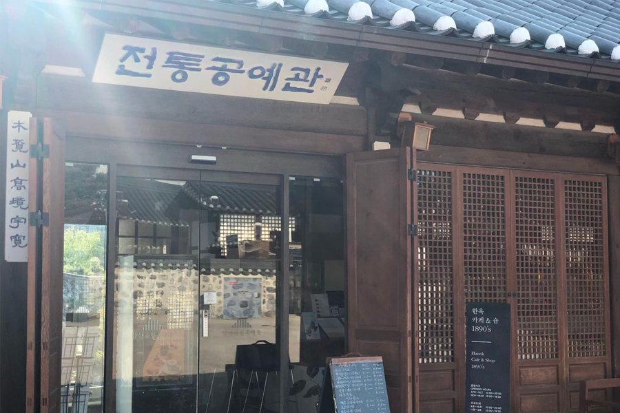 Interior spaces of Namsan Hanok Village complete with wooden light fixtures and traditional decor harmonizing with the environment.