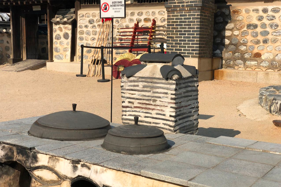 An outdoor traditional kiln at Namsan Hanok Village used historically for steaming rice cakes and cooking.