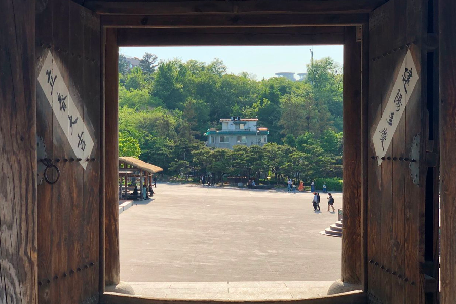 Traditional wooden gate of Namsan Hanok Village offering a welcoming view into the cultural experiences beyond.