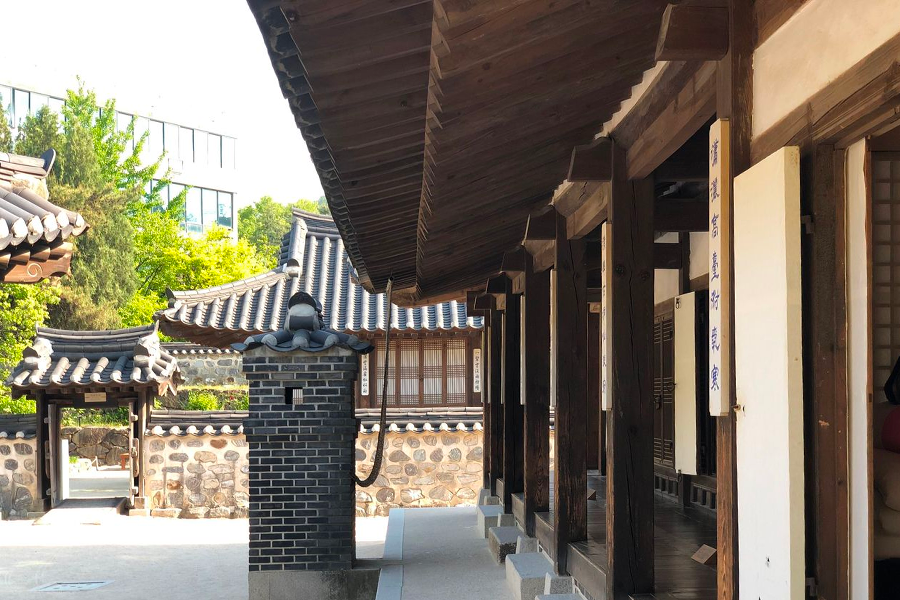 An outdoor scene in Namsan Hanok Village displaying traditional Korean houses and archery targets.