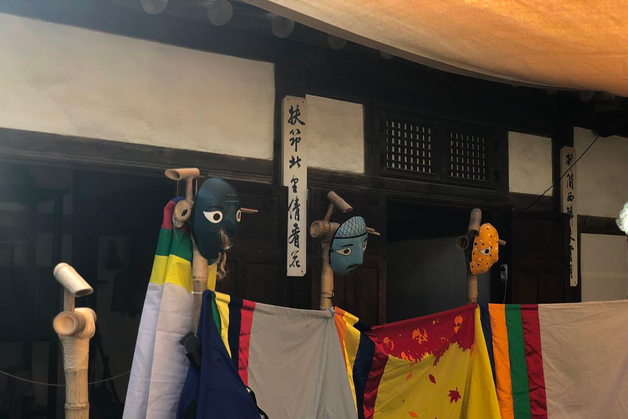 Courtyard decorations of wooden benches and artifacts in Namsan Hanok Village creating a nostalgic atmosphere.