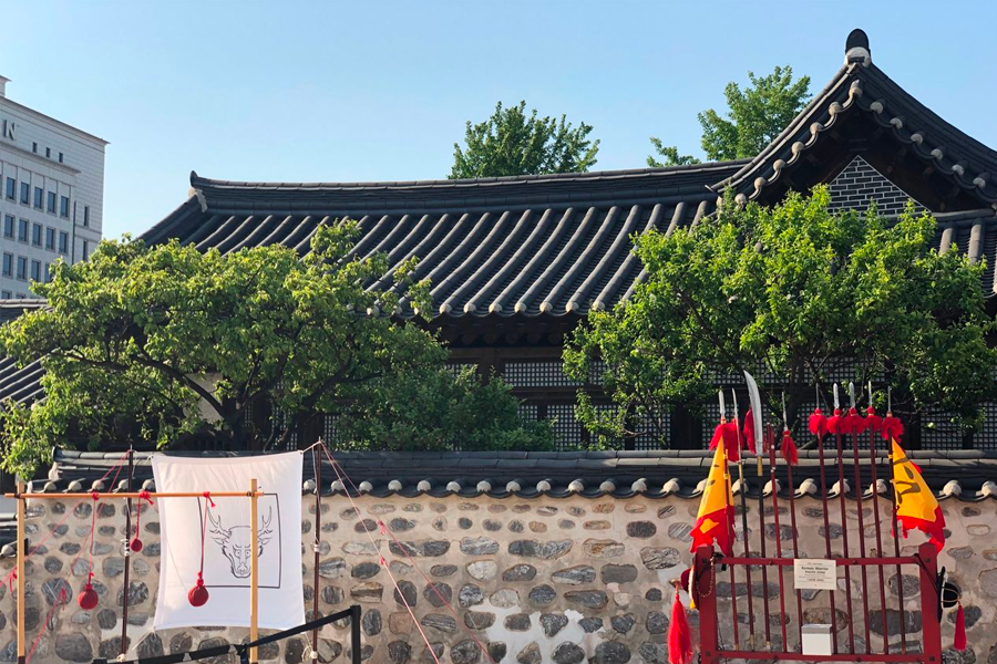 Main gate of Namsan Hanok Village featuring wooden architecture, transporting you from the bustling city into a historical haven.
