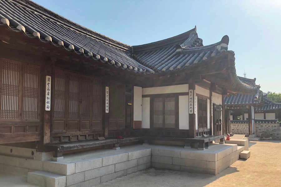 Namsan Hanok Village's serenity captured with traditional Korean homes set against the modern city backdrop.