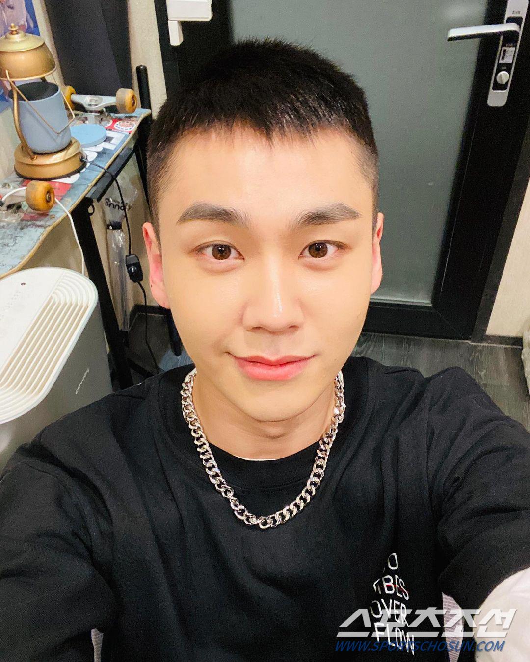 室内で黒いTシャツと銀色のネックレスを身に着けた男性のセルフィー