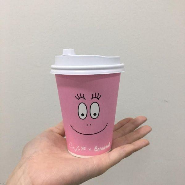 손 위에 올려진 바바파파 커피컵, 부드러운 핑크색과 웃는 얼굴 디자인이 특징인 컬렉터 아이템.