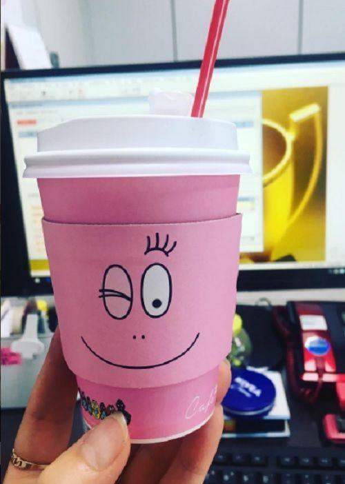 의자에 앉아있는 바바파파 핑크 커피컵, 우측에 빼곡한 사무실 배경이 특징인 일상 속 독특함.