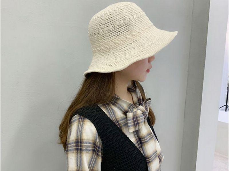 Mũ cói với thiết kế đơn giản và màu sáng, phối với áo sơ mi kẻ sọc và áo gile len.