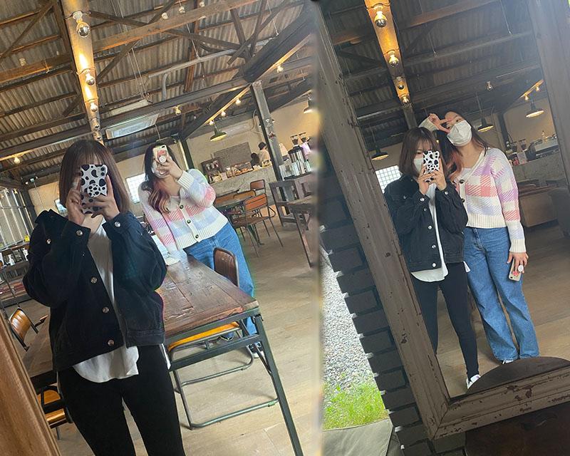 two girls posing in the mirror at house plant cafe