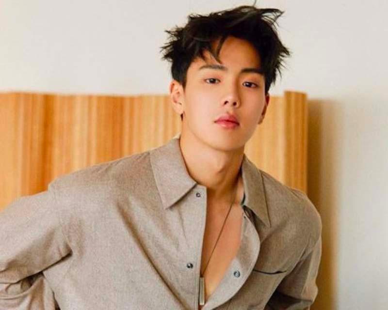 ชยอนู MONSTA X ในเสื้อเชิ้ตคอปกสีน้ำตาลถ่ายในห้องนั่งเล่น