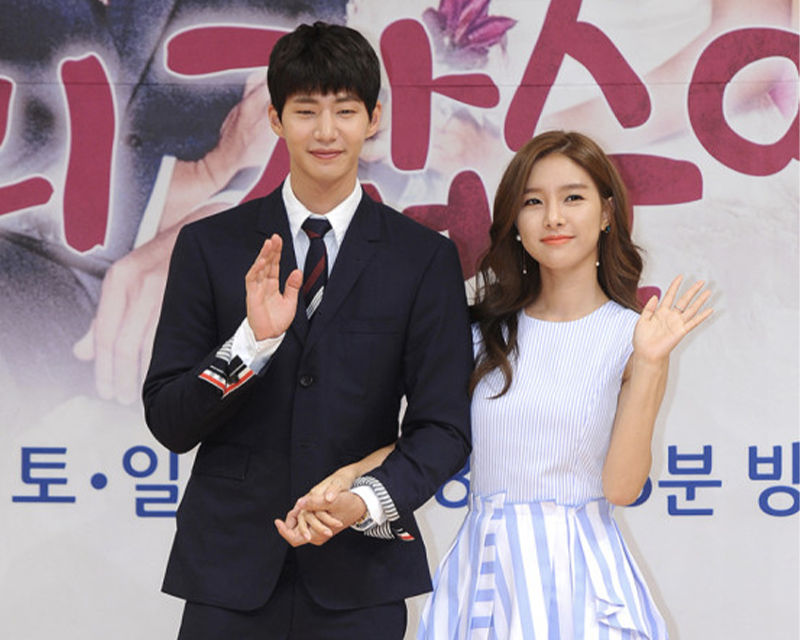 韓國綜藝《我們結婚了》中的精靈夫婦在户外活動中，女性穿著藍白條紋連衣裙，男性穿著正式西裝