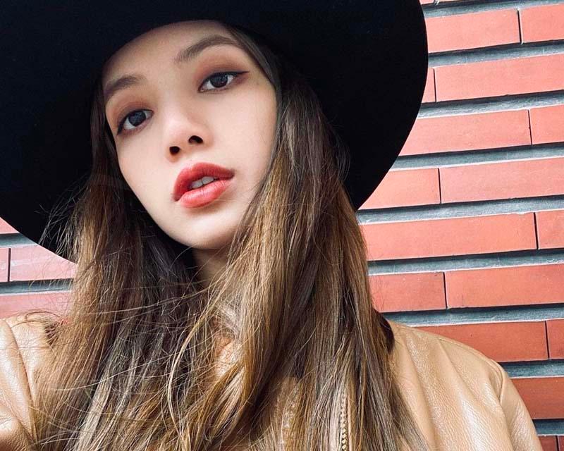 หญิงสาวเกาหลีสวมหมวกปีกกว้างสีดำกับแจ็คเก็ตหนังสีน้ำตาล ลุคที่เพิ่มความเท่ในบรรยากาศเรียบง่าย