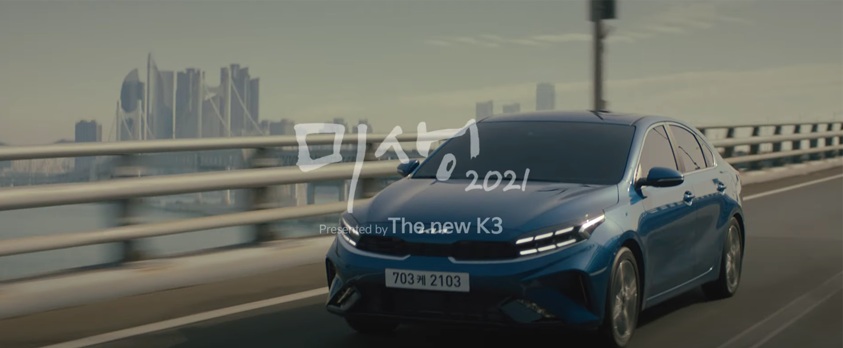 未生2021广告中的KIA新款K3在城市桥梁上行驶，展示产品的便捷与时尚。