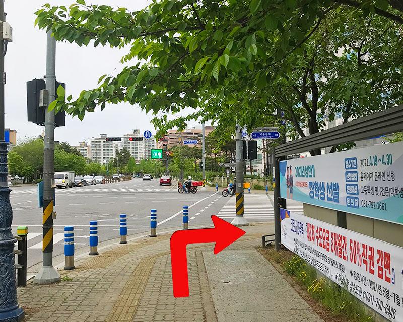 韓國京畿道河南市內街道的全景，顯示路牌指向一幢建築的方向。