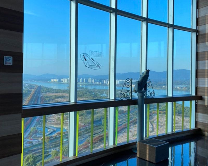 從韓國京畿道河南市Union Tower塔內觀看外界景色的視圖，顯示城市與遠方的山脈。