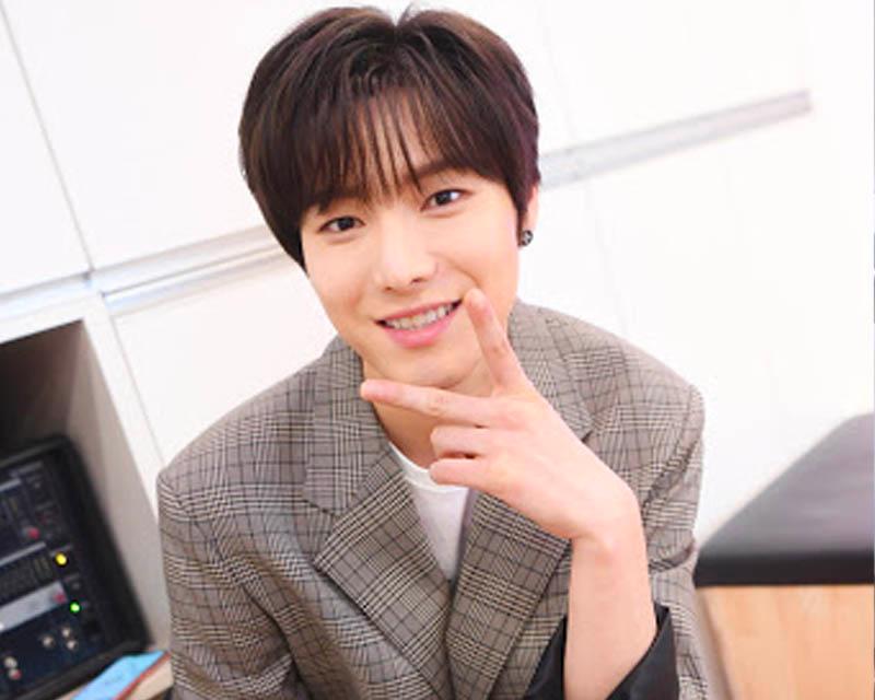 ONEWE主唱勇訓身穿白色襯衫，背景是簡潔的淺灰色，作為東亞放送藝術大學的校友，他的音樂才華備受肯定。