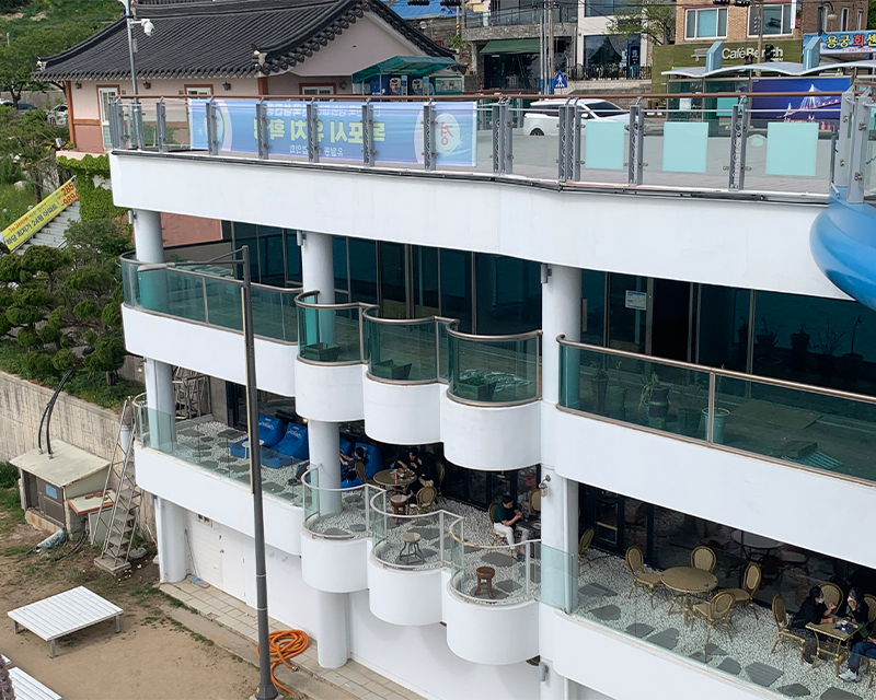 木浦觀景咖啡廳的側視圖,白色建築設計及其周圍環境。